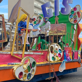 Artists on a float painting art. Float says GIS with paint palettes and art.