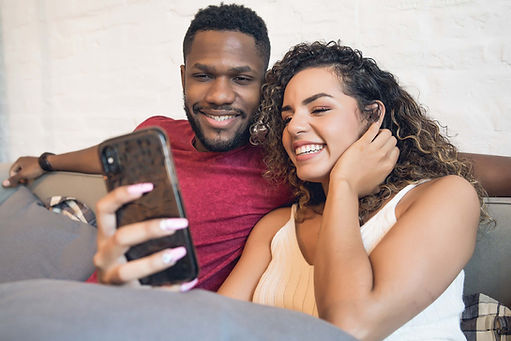 young-couple-using-mobile-phone-while-sitting-couch-home-stay-home-new-normal-lifestyle-co