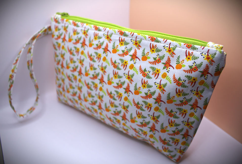 Zippered pouch approx. 8 inch wide by 6 inch. length, with wrist strap. white with lime & orange colored floral sprigs pattern fabric. Lime accent zipper.