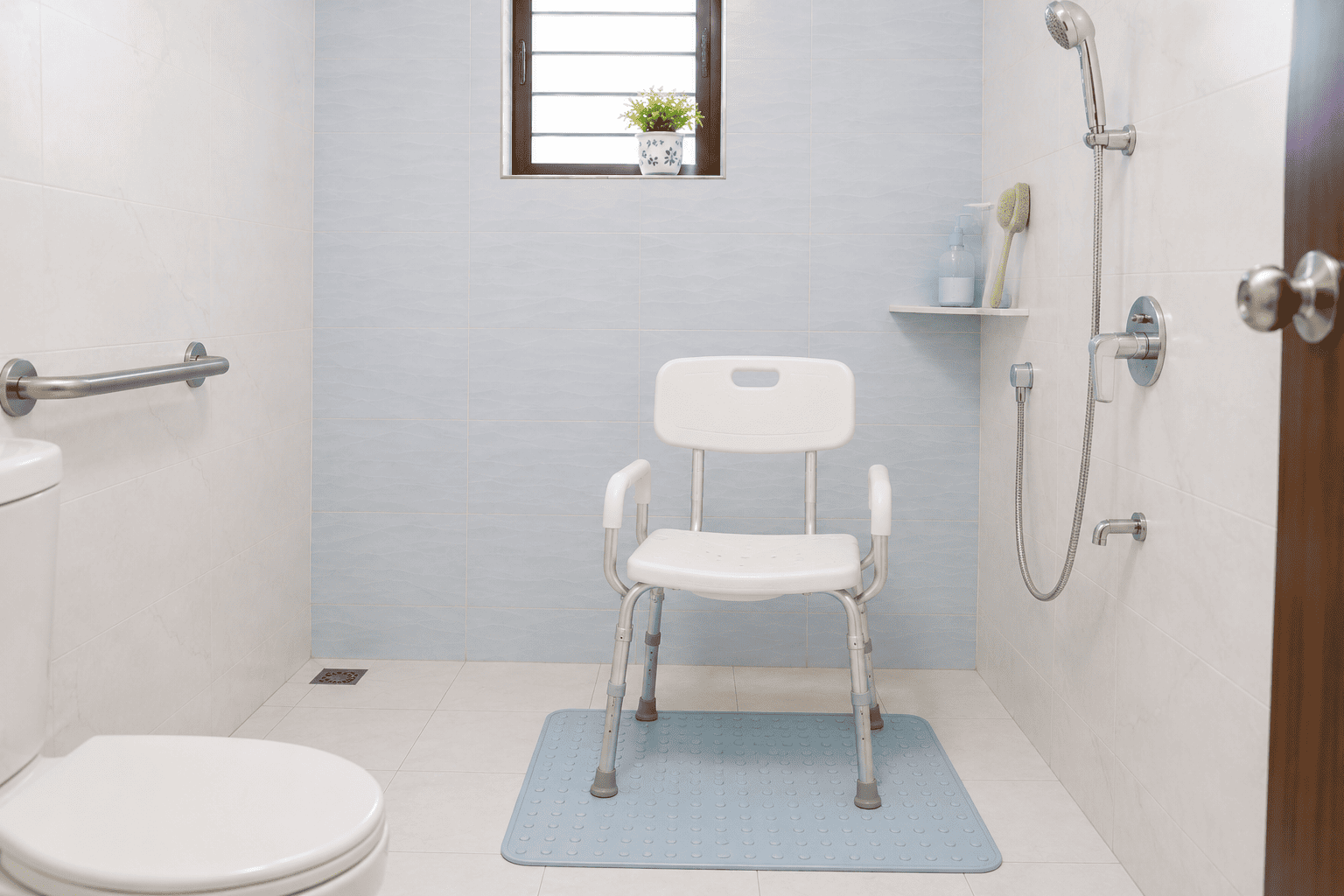 Shower chair with rubber tips and handheld shower set up in an Indian bathroom for a recovering patient