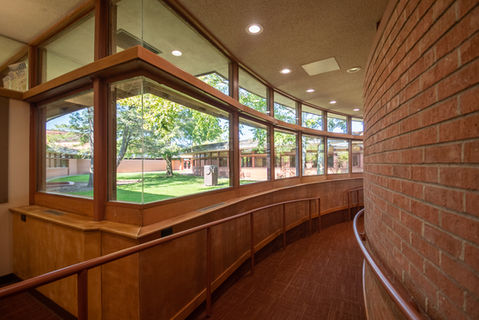 Curved wooden hallway overlooking a courtyard