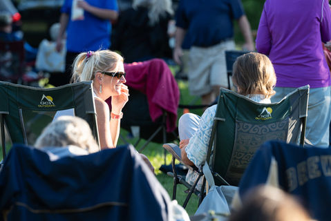 People sitting outdoors in a park, conversing.