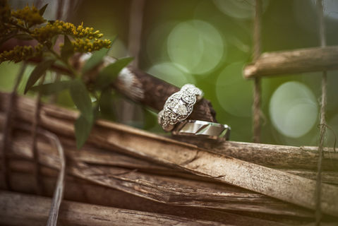 Diamond engagement ring and wedding band on natural wood