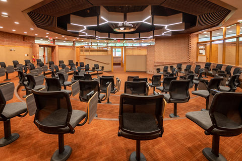 Circular conference room with orange carpet and chairs