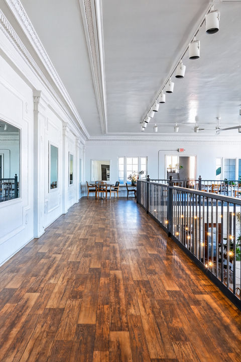 Bright commercial interior with wooden floor and railing