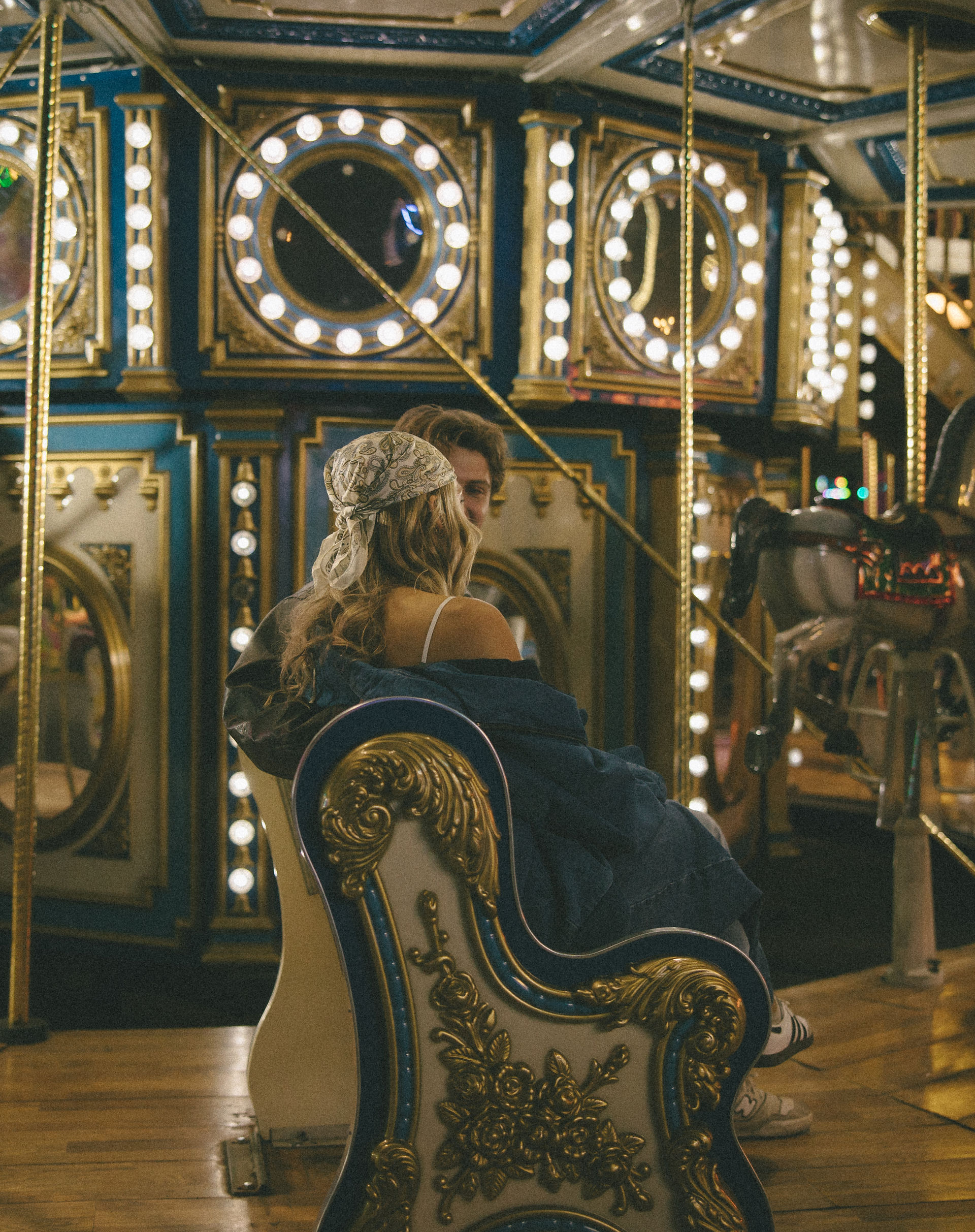 A couple riding a carousel during their engagement photos