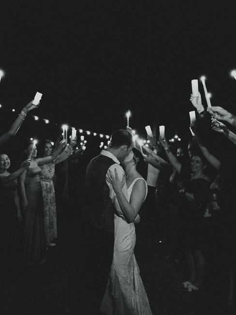 Bride and groom kissing during their sendoff at their backyard wedding