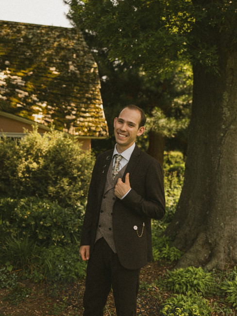 A groom smiling for a wedding portrait