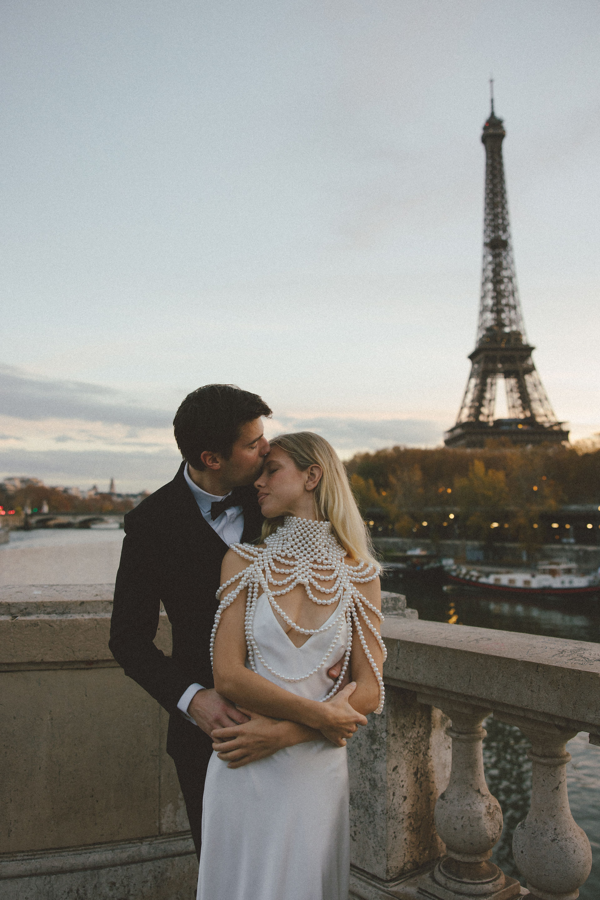 A bride and groom posing in front of the Eiffel Tower