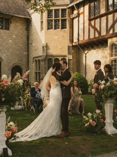 A groom kissing a bride on the forehead in documentary style wedding photography