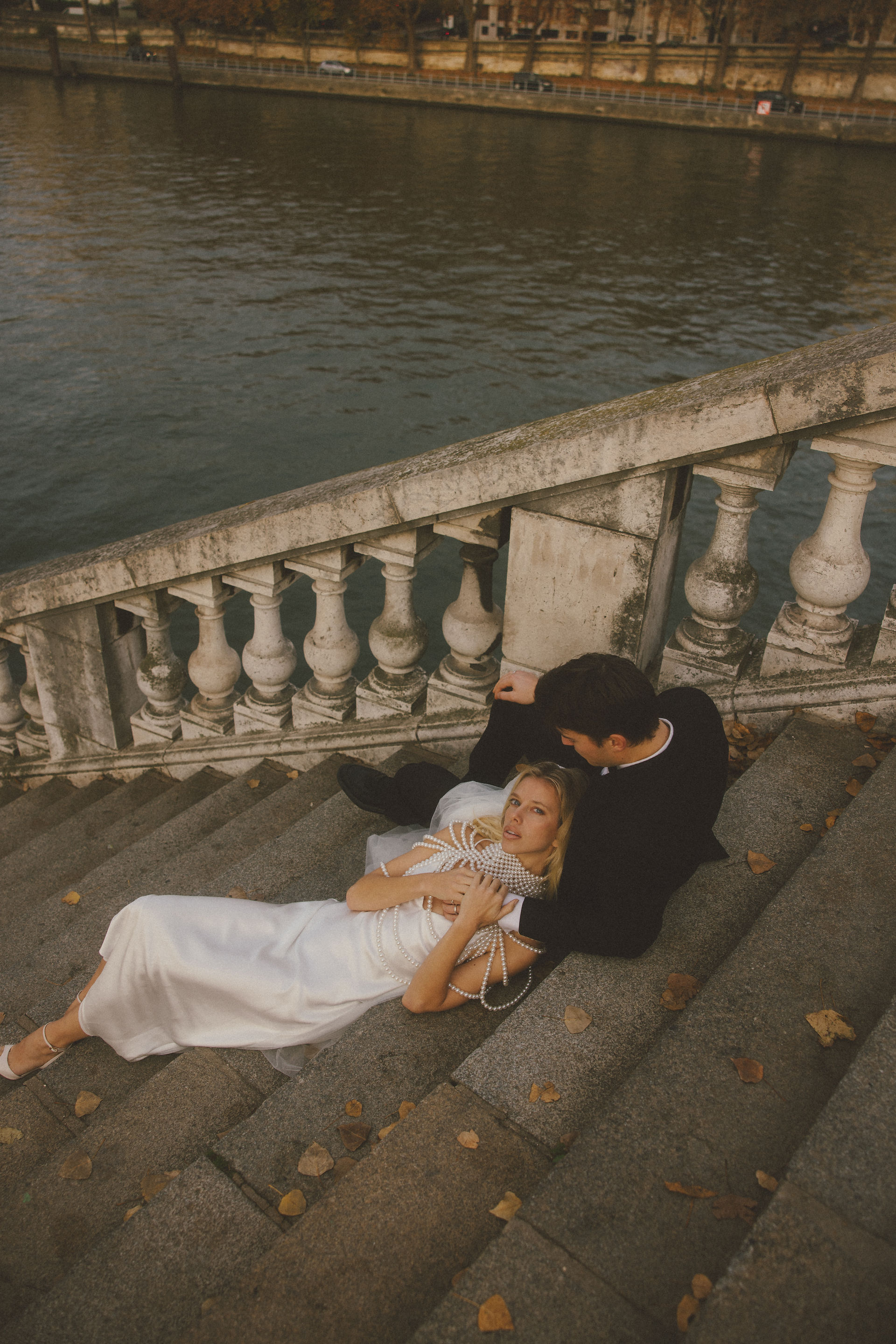A bride and groom lying on stairs for elopement photos in Paris