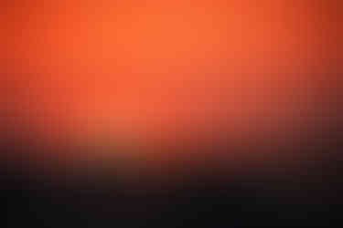 Ein Surfer reitet eine Welle und bildet die Silhouette.