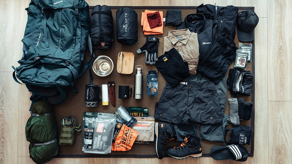 Outdoor gear for a trekking trip layerd on the floor.