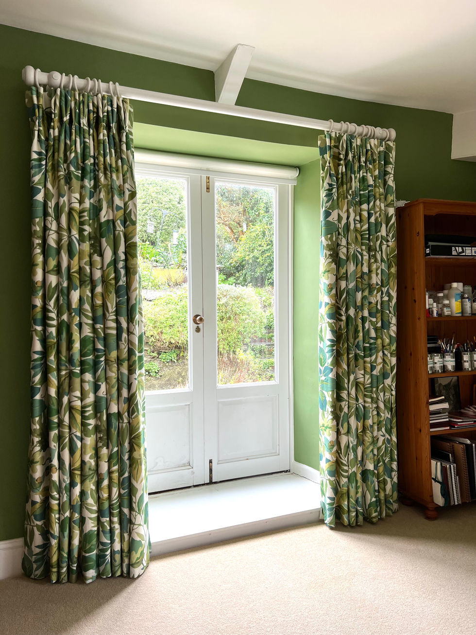 Sanderson green leaf print curtains with a double pinch heading.