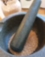 Grinding home grown mustard seed with a mortar and pestal.