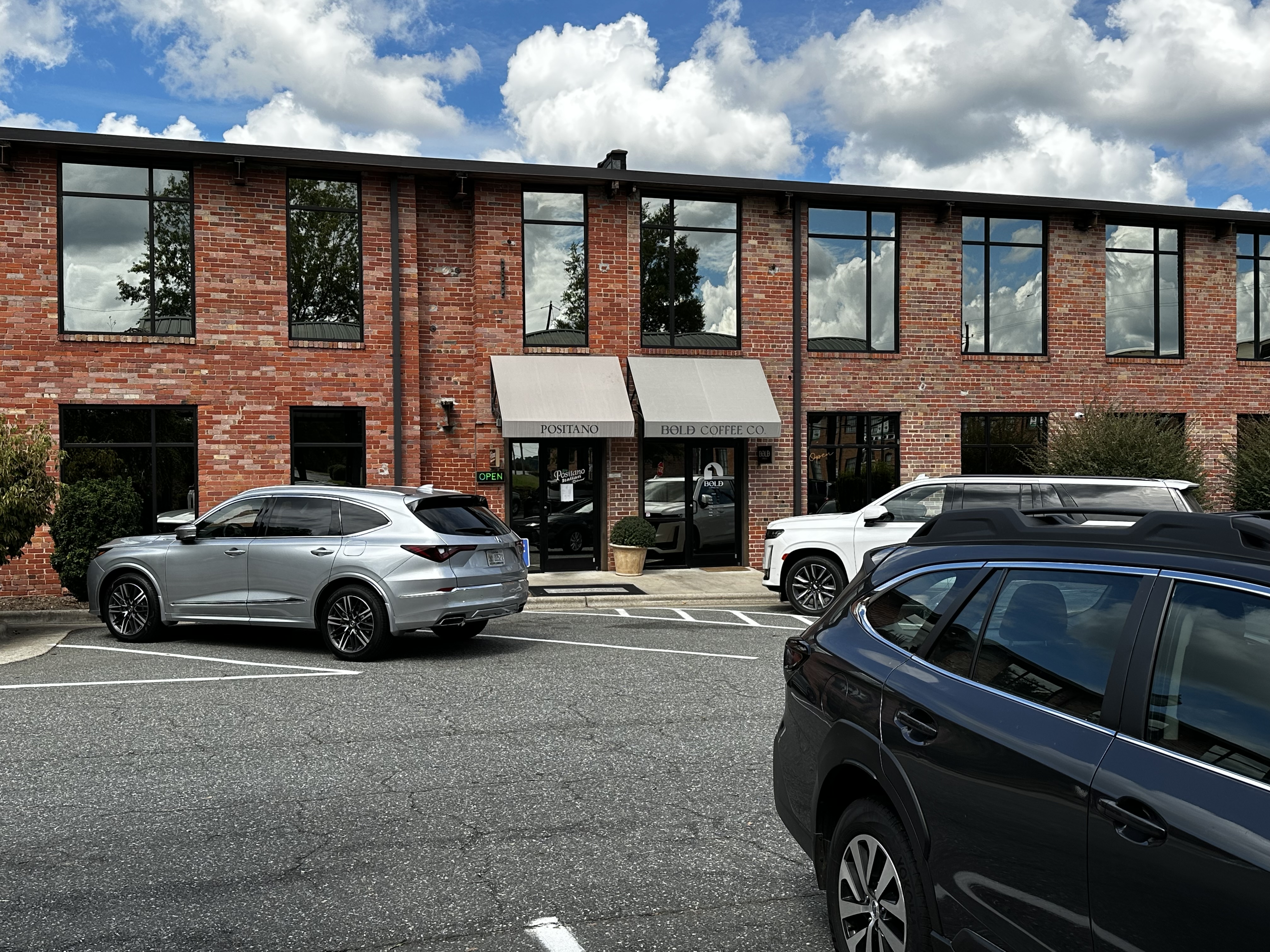 Shared brick building with signed entrances for Positano and Bold Coffee Co. in Asheboro.