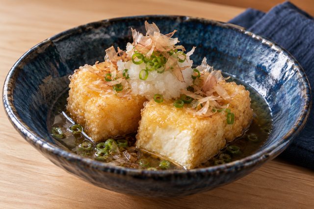 Illustration: Japanese agedashi tofu with daikon. Fictional scene; not a photograph of this business or its actual menu.