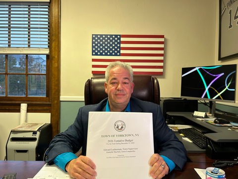 Town Supervisor Ed Lachterman holding a copy of his 2026 tentative town budget.