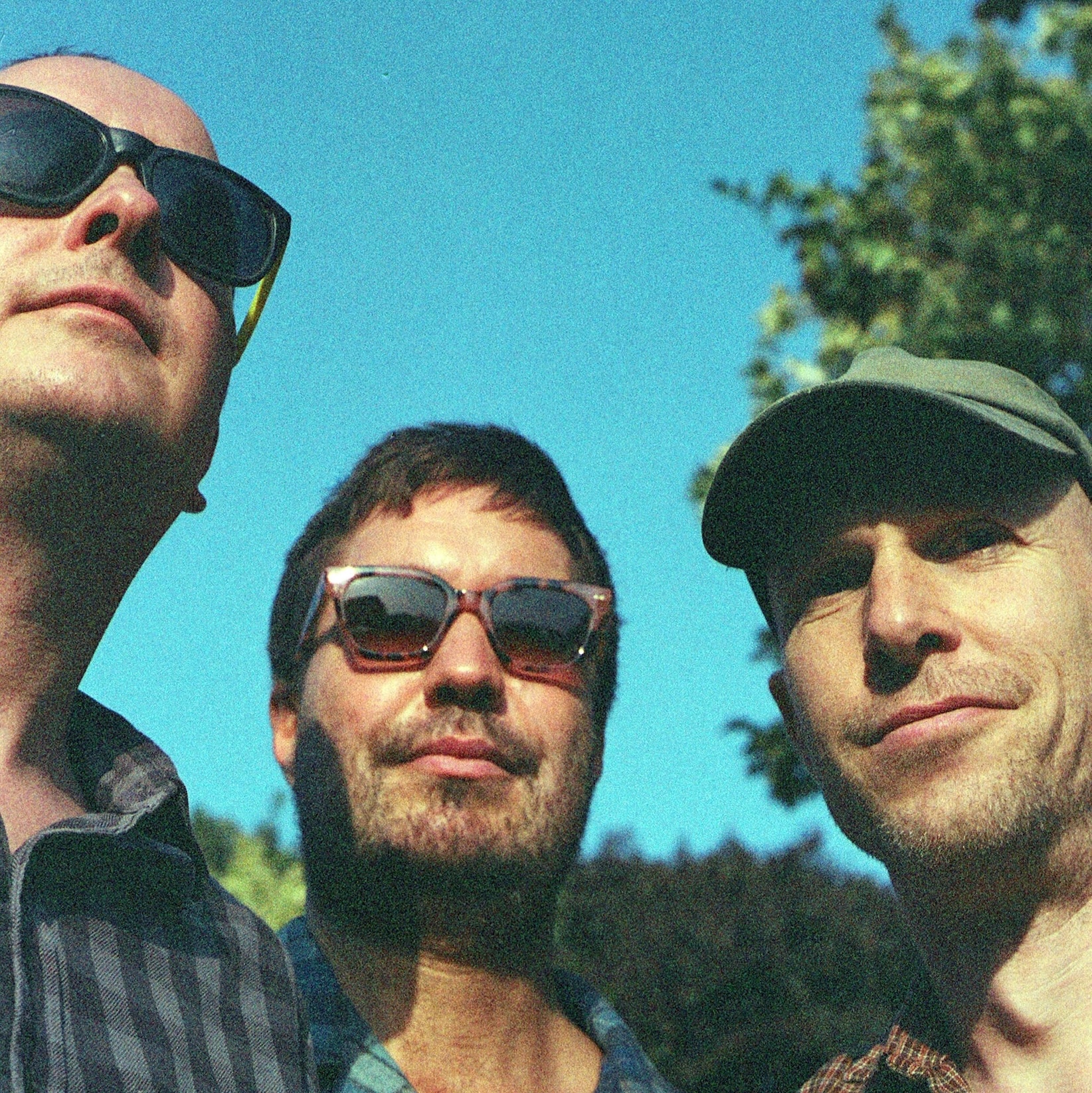 David Tattersall, Franic Rozycki and Jonny Helm of The Wave Pictures photographed together outdoors against a blue sky
