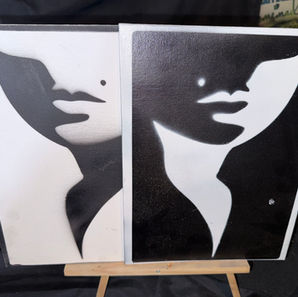Black -and-white diptych portrait featuring two stylized female faces with beauty marks, rendered in a minimalist high-contrast stencil style