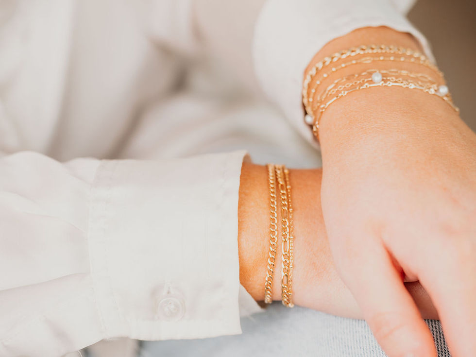 Close-up view of a delicate gold permanent bracelet on a wrist