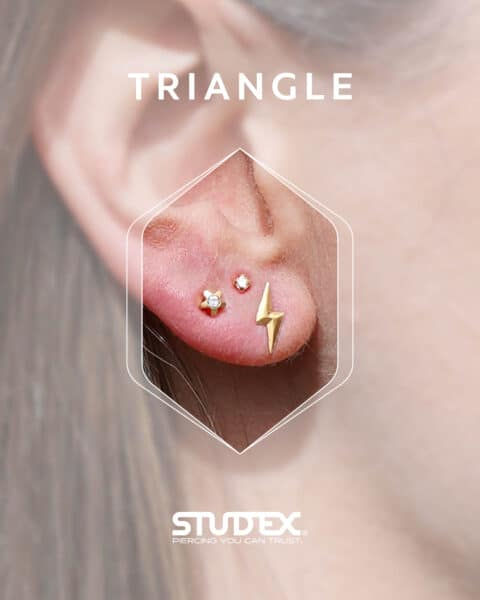 Floating third lobe piercing with three earrings arranged in a triangle.