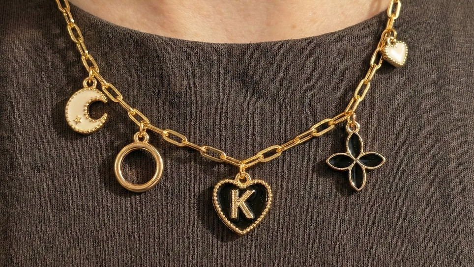 Gold charm necklace with K initial and black accents