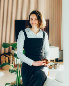Vrouw met kort haar zit met kopje op de bank