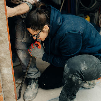 Vrouw werkt met gereedschap aan een kozijn
