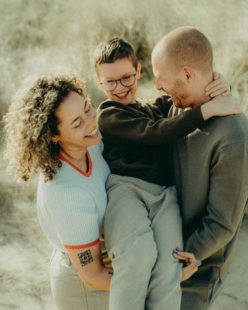 Lachende ouders die hun kind vasthouden.