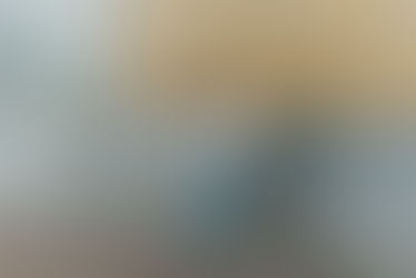 Lachende vrouw leunt tegen gele bakstenen muur