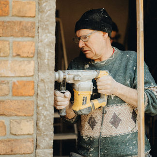 Man boort in muur met boorhamer