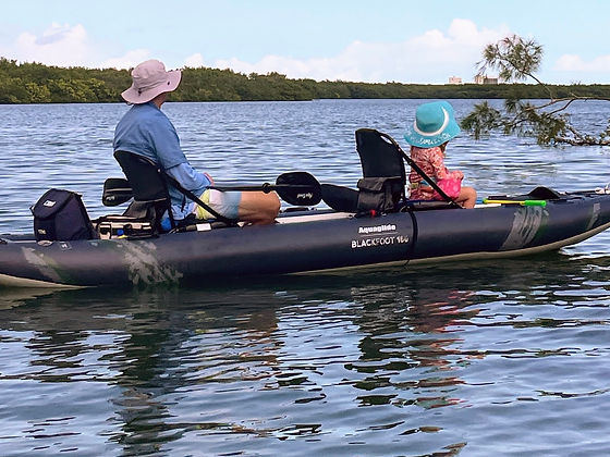 family kayaking watching dolphins
