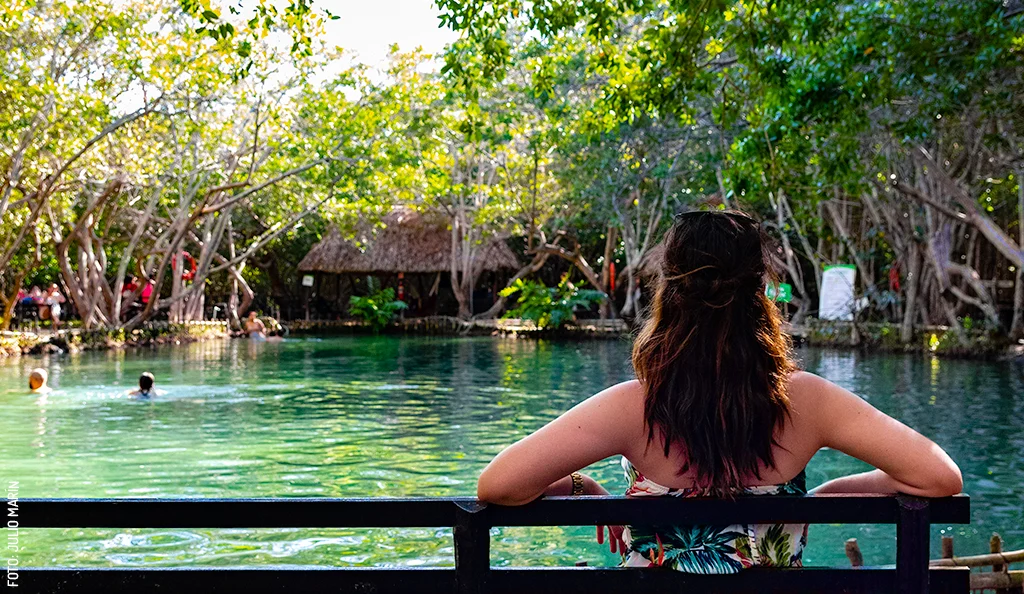Woman overlooking the cenote at Corchito Nature Reserve.
