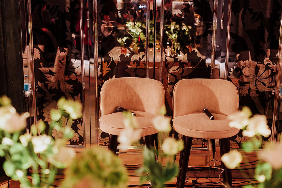 Fireside chat stage set with two armchairs and flowers before guests arrive at Rosewood London