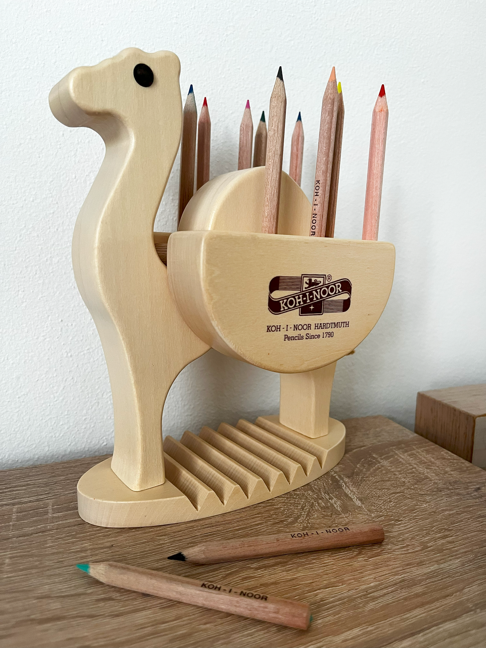 Crayon organizer in the shape of a camel on a wooden table.