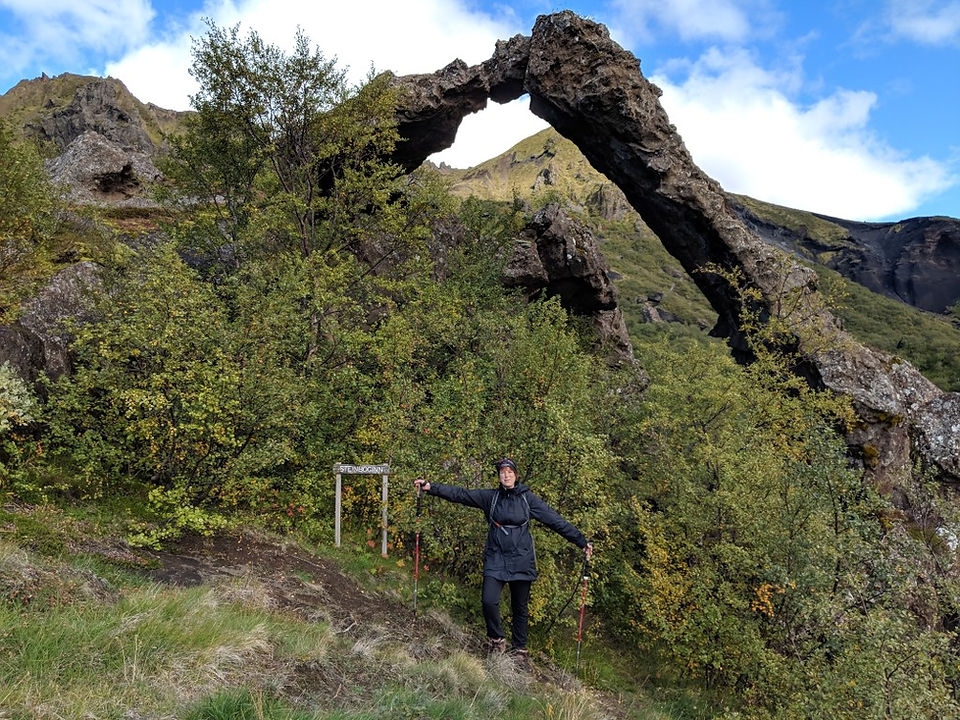 A hiker infront of a stone arc in Thorsmork