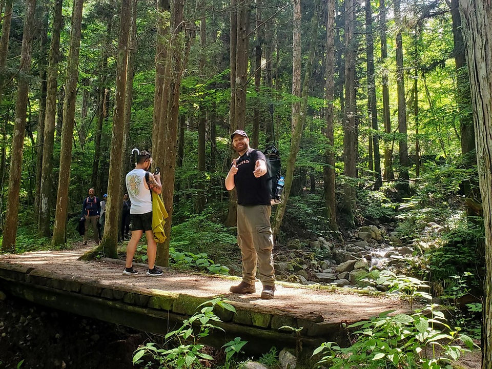 Hikers on a wooden bridge next to Otaki - Metaki waterfalls