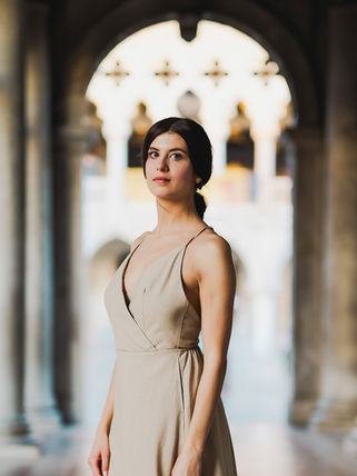 Femme élégante posant en robe longue entre les colonnes d’un palais vénitien