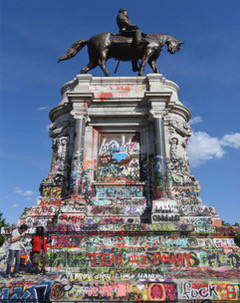Statue of Robert E. Lee with grafitti comments about his role in the Civil War.