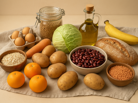 Assortiment d’aliments sains et économiques disposés sur un tissu beige : pommes de terre, carottes, chou, œufs, haricots rouges, lentilles, flocons d’avoine, pain, banane, oranges et huile d’olive, dans une ambiance naturelle et chaleureuse.