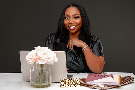 Brand portrait of a businesswoman at a styled white desk with laptop and flowers