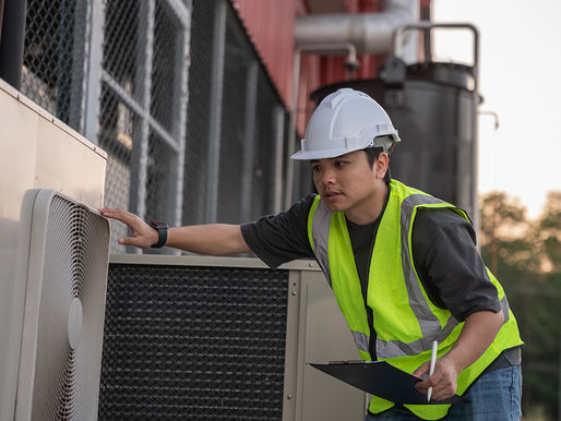 Engineers are inspecting the cooling system of an air conditioning unit in industrial facility.