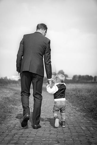 Man in suit with child holding hands