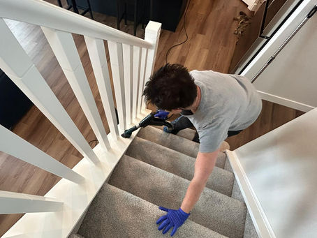 House cleaner in Cochrane vacuuming the stair runners. 