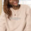 Miniatura: Smiling woman wearing RI CLOTHING NORTH AMERICA sweatshirt, www.r1clothing.com