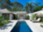 Serene outdoor space featuring a crystal-clear pool, tropical plants, lounge chairs, and a shaded seating area under a stylish pavilion.