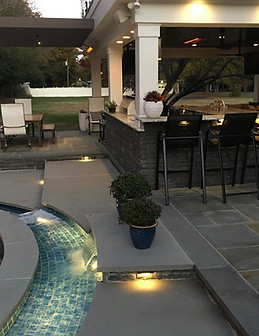 Custom outdoor patio with lighting and a pool