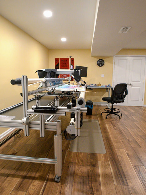 Craft room with quilting machine and wooden floors.