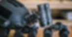 A helmet lying on a table has an attached binocular night vision device. Additional binoculars are on the table.